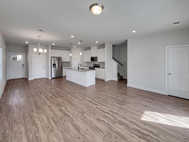 unfurnished living room featuring a chandelier, recessed lighting, and light wood-style flooring
