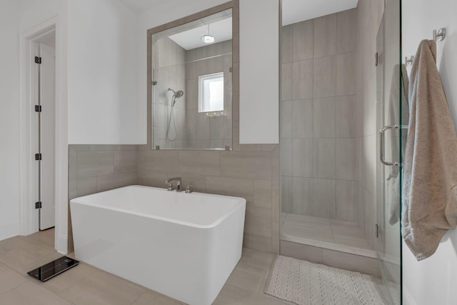 full bath featuring tile walls, a tile shower, tile patterned flooring, and a soaking tub
