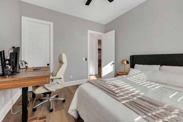 bedroom with a ceiling fan, wood finished floors, and baseboards