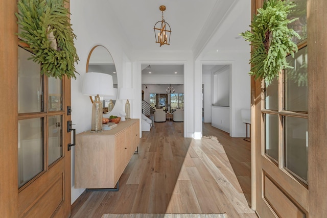 foyer featuring crown molding, a chandelier, baseboards, recessed lighting, and light wood finished floors