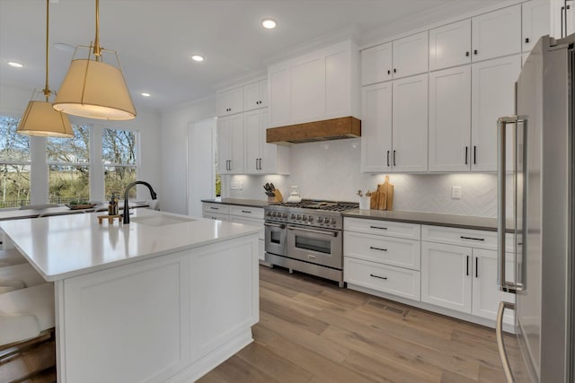 kitchen with recessed lighting, decorative backsplash, appliances with stainless steel finishes, white cabinets, and a sink