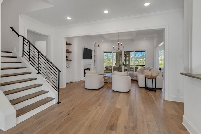 living room featuring a fireplace, stairs, beam ceiling, and light wood-style floors