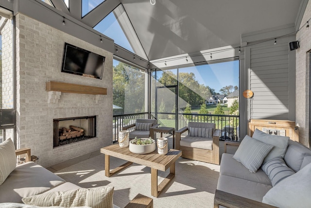 sunroom with an outdoor living space with a fireplace and plenty of natural light