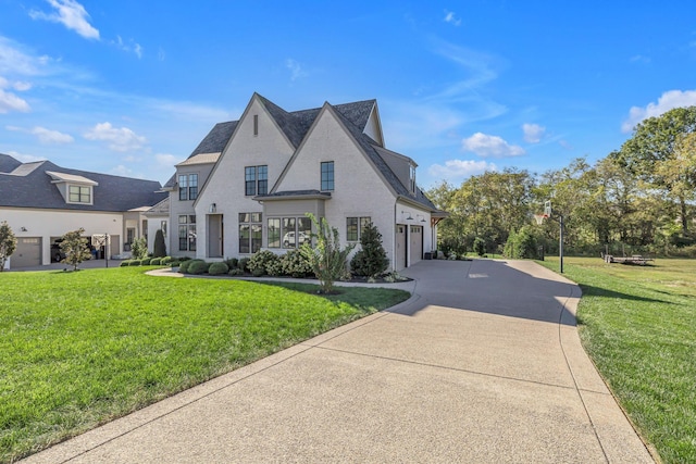french country style house featuring a front yard, driveway, and an attached garage