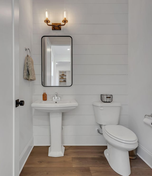 half bathroom featuring toilet and wood finished floors