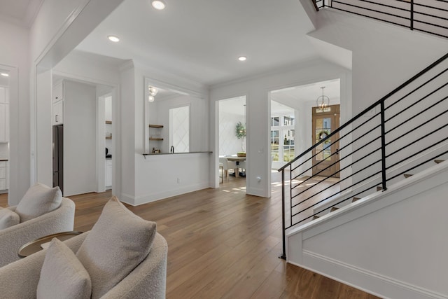 living area featuring baseboards, recessed lighting, wood finished floors, and stairs