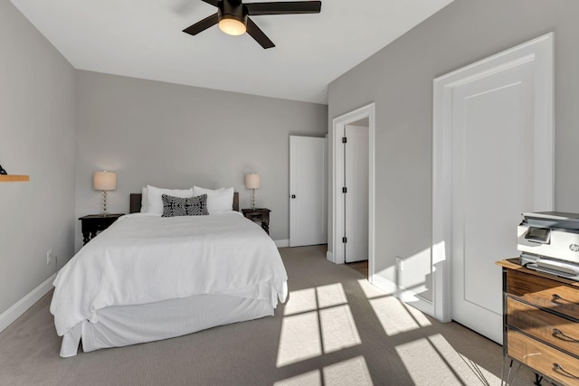bedroom featuring ceiling fan, light colored carpet, and baseboards