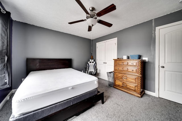 bedroom with ceiling fan, a textured ceiling, a closet, carpet flooring, and baseboards