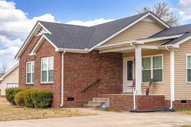 view of front of home with brick siding, crawl space, and a shingled roof