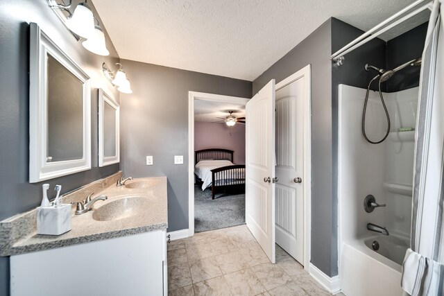 bathroom featuring baseboards, double vanity, a sink, and shower / washtub combination