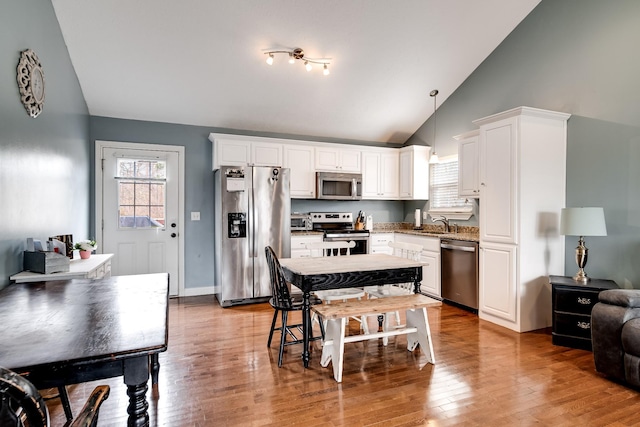 kitchen featuring a wealth of natural light, white cabinets, and appliances with stainless steel finishes