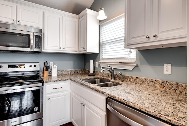 kitchen with a sink, white cabinets, light stone counters, and stainless steel appliances
