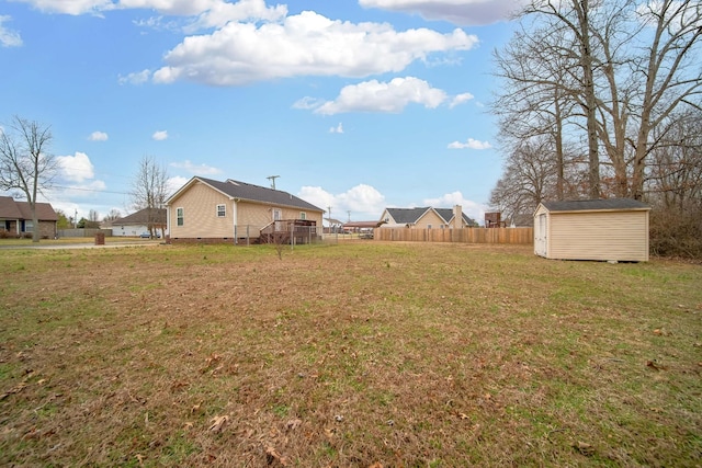 view of yard with a storage shed, fence, and an outdoor structure
