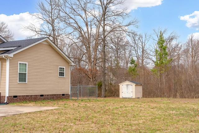 view of yard with a storage shed, fence, and an outbuilding