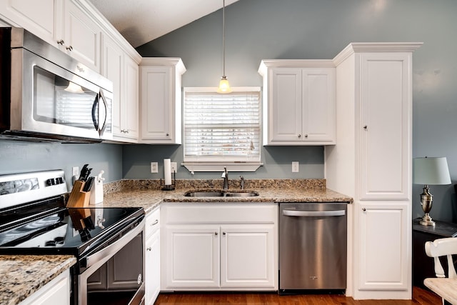 kitchen featuring a sink, white cabinetry, vaulted ceiling, and stainless steel appliances