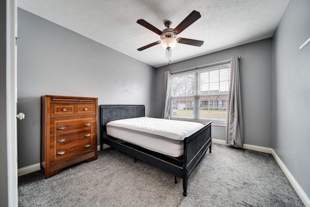 carpeted bedroom featuring a textured ceiling, ceiling fan, and baseboards