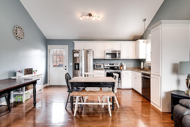 kitchen featuring white cabinets, a sink, appliances with stainless steel finishes, a toaster, and lofted ceiling