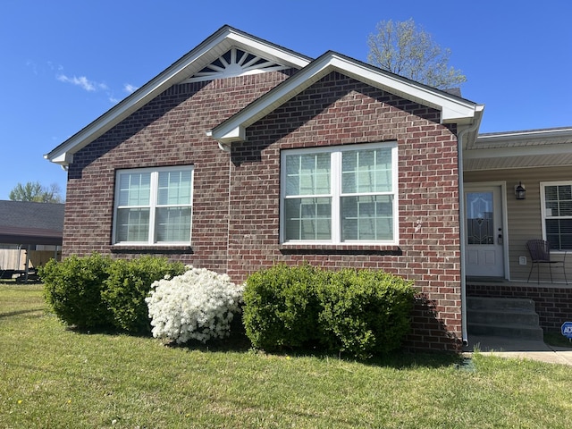 view of side of home featuring a yard and brick siding