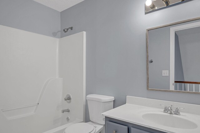 full bathroom with vanity, shower / tub combination, toilet, and a textured ceiling