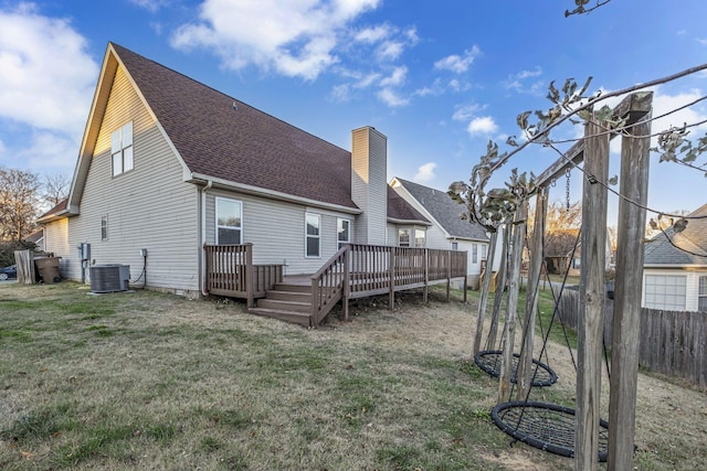 back of house featuring cooling unit, fence, roof with shingles, a yard, and a deck