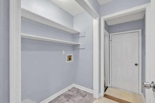 clothes washing area featuring baseboards, light floors, washer hookup, and laundry area
