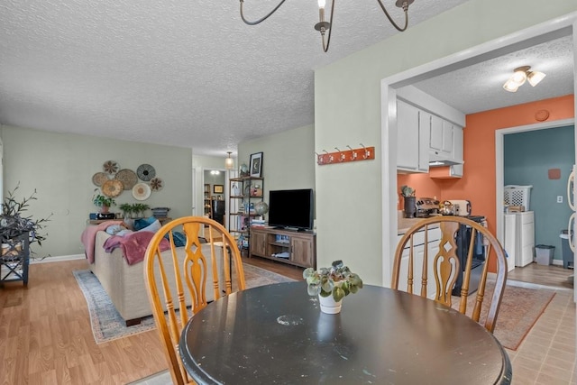 109 Robin Hood Rd, Dickson, TN 37055 - dining room featuring a textured ceiling, baseboards, washer / clothes dryer, and light wood-style flooring
