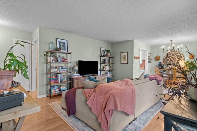 109 Robin Hood Rd, Dickson, TN 37055 - living room with baseboards, a textured ceiling, light wood-style floors, and a notable chandelier
