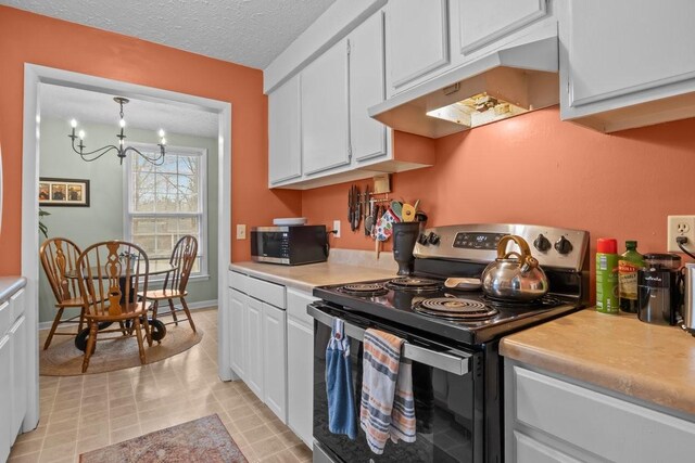 109 Robin Hood Rd, Dickson, TN 37055 - kitchen featuring white cabinetry, light countertops, stainless steel microwave, under cabinet range hood, and black range with electric stovetop