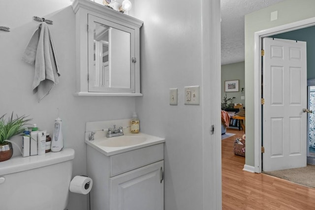 109 Robin Hood Rd, Dickson, TN 37055 - bathroom with a textured ceiling, baseboards, toilet, wood finished floors, and vanity