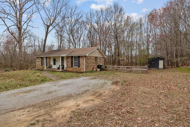 109 Robin Hood Rd, Dickson, TN 37055 - view of front of property with an outdoor structure, brick siding, a shed, and fence
