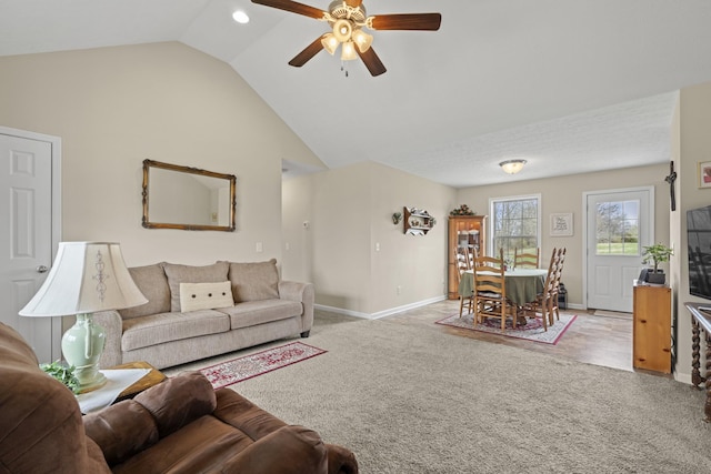 carpeted living room featuring vaulted ceiling, a ceiling fan, and baseboards