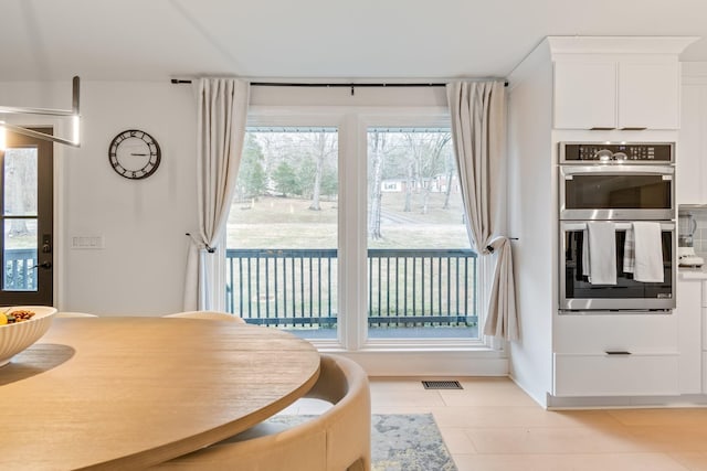dining area featuring light tile patterned flooring and visible vents