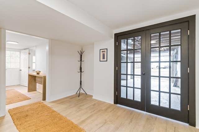 entrance foyer with baseboards, wood finished floors, and french doors