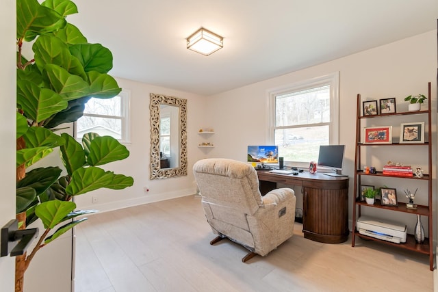 office with baseboards, a healthy amount of sunlight, and wood finished floors