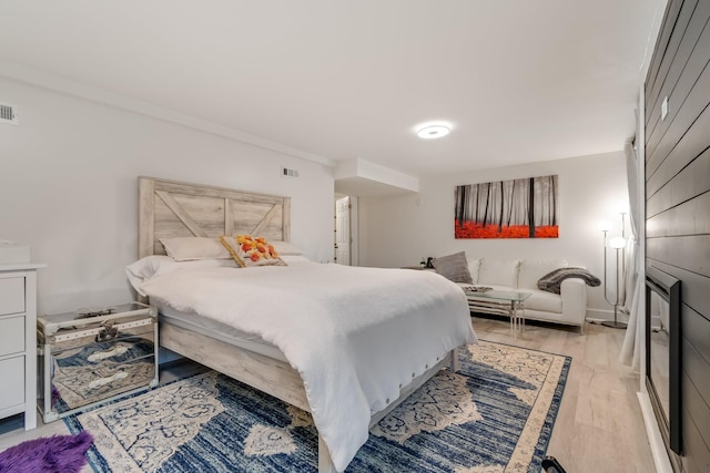 bedroom with light wood-style floors and visible vents