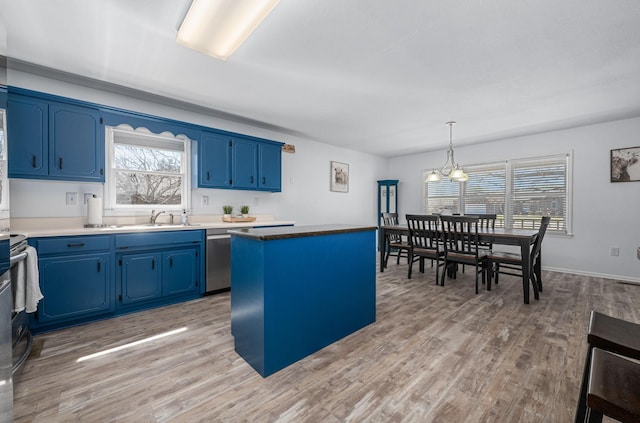 kitchen featuring blue cabinetry, a center island, light wood-type flooring, and a sink