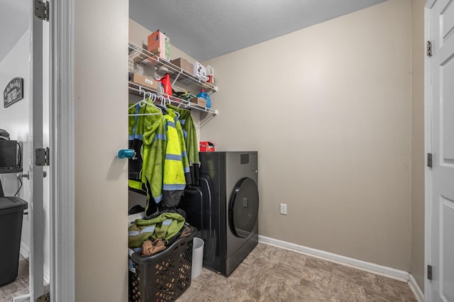 laundry area featuring baseboards, a textured ceiling, washer / dryer, and laundry area
