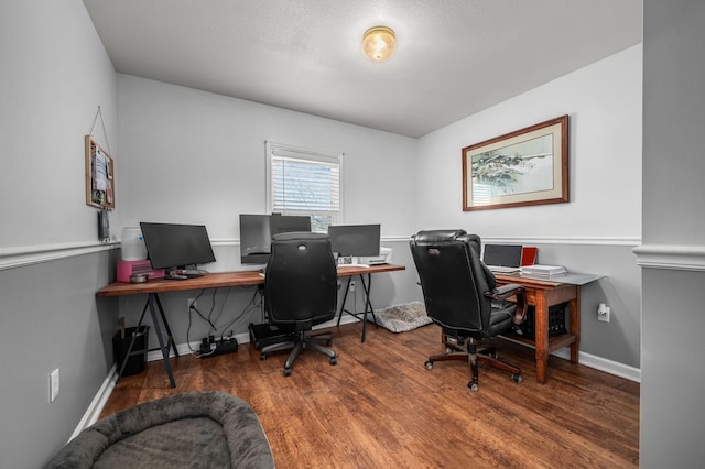 office space featuring baseboards and wood finished floors