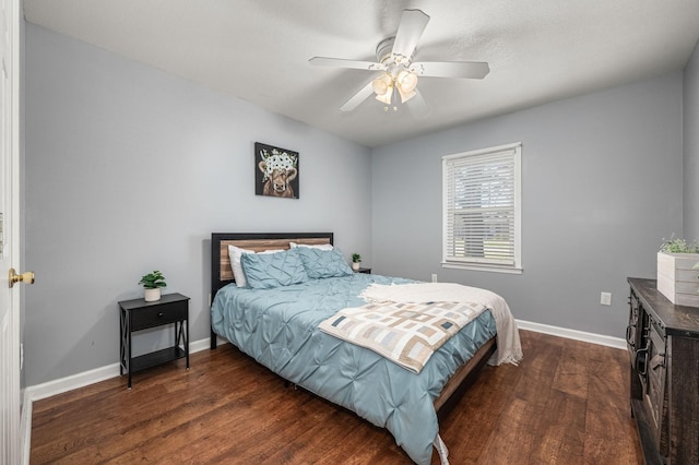 bedroom featuring baseboards, a ceiling fan, and dark wood-style flooring