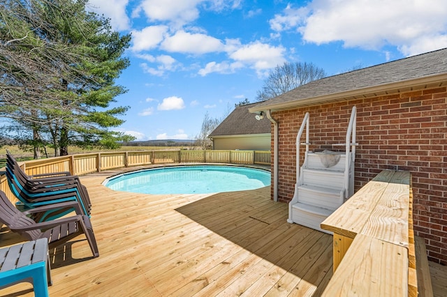 view of pool with a fenced in pool and a wooden deck