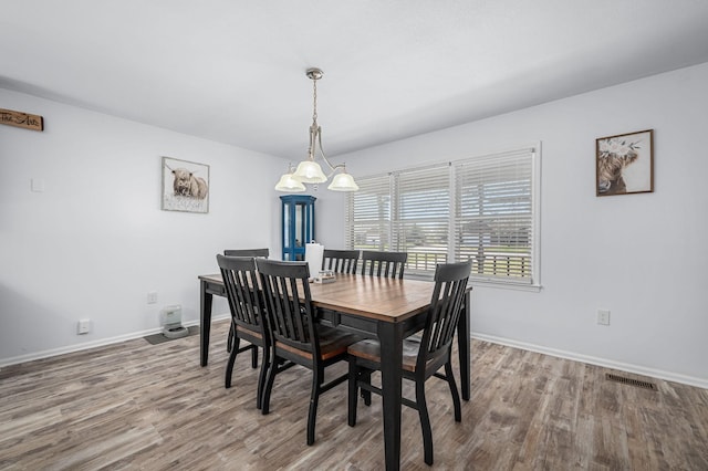 dining room with visible vents, baseboards, and wood finished floors