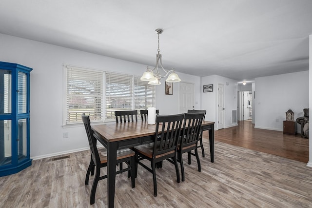 dining room with visible vents, baseboards, an inviting chandelier, and wood finished floors