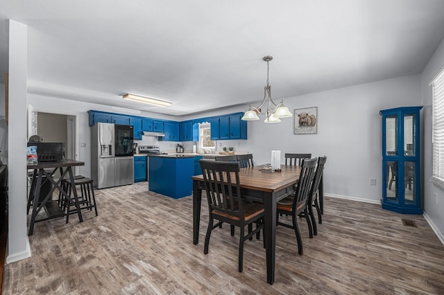 dining space featuring visible vents, baseboards, and wood finished floors