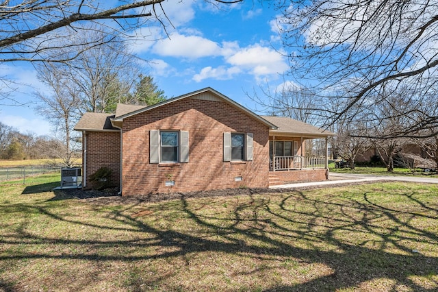 view of home's exterior featuring fence, a porch, a yard, a shingled roof, and brick siding