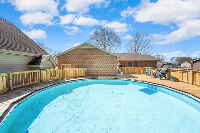 view of swimming pool with a wooden deck and a fenced in pool