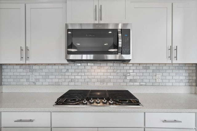 1044 Thrasher Dr, Clarksville, TN 37040 - kitchen featuring light stone counters, tasteful backsplash, appliances with stainless steel finishes, and white cabinetry