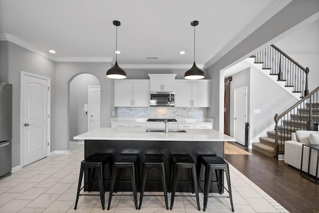 1044 Thrasher Dr, Clarksville, TN 37040 - kitchen featuring a sink, light countertops, arched walkways, and stainless steel appliances