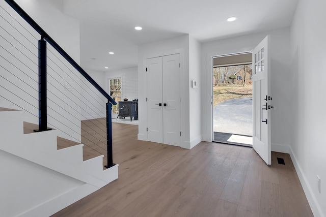 foyer entrance with recessed lighting, stairway, baseboards, and wood finished floors
