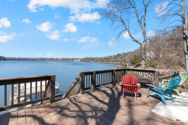 view of dock featuring a deck with water view and an outdoor fire pit
