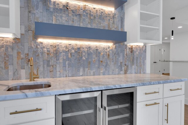 bar featuring a sink, decorative backsplash, wine cooler, and wet bar